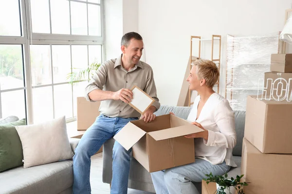 Mature couple packing things in room on moving day