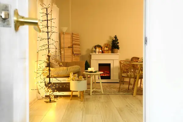 Interior of cozy living room with Christmas table setting at evening, view through doorway