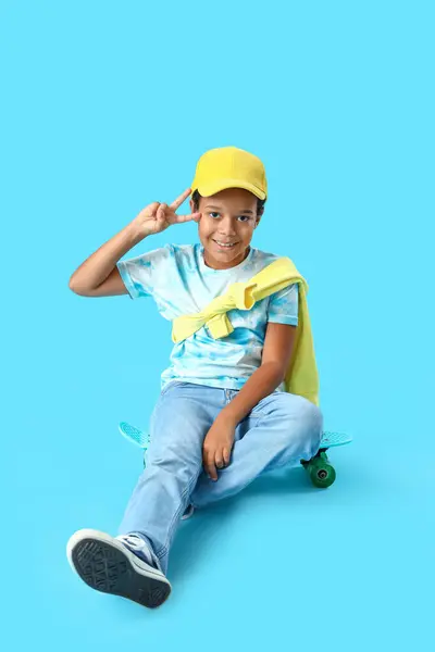 Afroamerikanischer Kleiner Junge Mit Skateboard Zeigt Siegesgeste Auf Blauem Hintergrund — Stockfoto