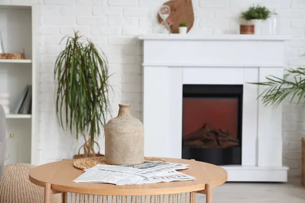 Tisch Mit Stilvoller Vase Und Zeitungen Neben Modernem Kamin Wohnzimmer — Stockfoto