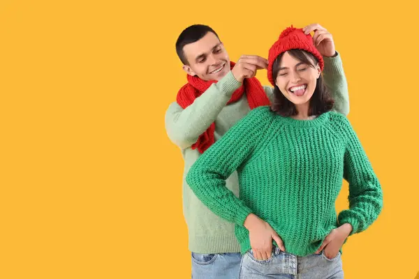 stock image Young couple in warm clothes on yellow background