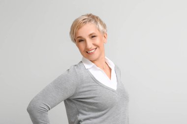 Mature blonde woman on light background