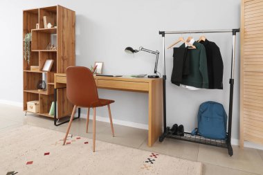 Modern iş yeri ve okul üniforması askıda olan şık bir oda.