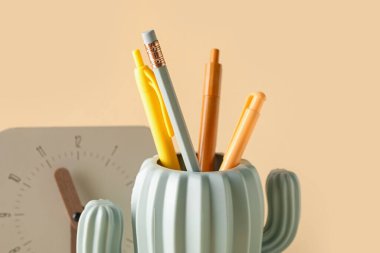 Renk arkaplanı üzerindeki kırtasiye ve saate sahip şık tutucu, kapat