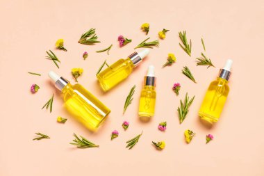 Soluk turuncu arka planda bitkilerle ve çiçeklerle dolu farklı sağlıklı yağlardan şişeler.