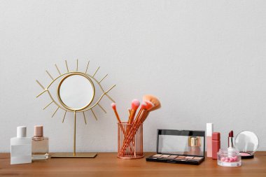 Odadaki ışık duvarının yanındaki makyaj malzemeleri ve aynalar farklı.