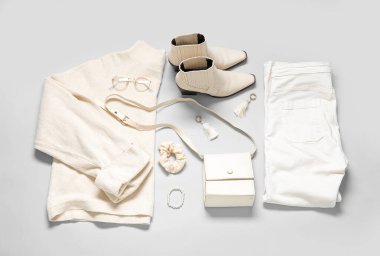 Gri arka planda şık kadın kıyafetleri, aksesuarları ve ayakkabıları olan kompozisyon