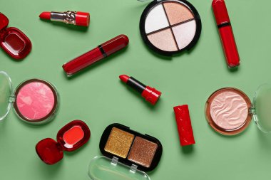 Yeşil arka planda farklı dekoratif kozmetik ürünler
