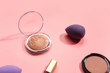 Pembe arka planda farklı dekoratif kozmetik ürünler