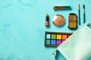 Grunge Blue arka planında dekoratif kozmetik ürünleri olan çanta