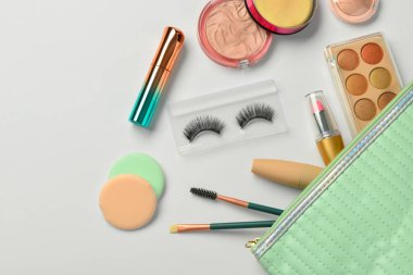 Beyaz arkaplanda dekoratif kozmetik ürünleri olan çanta