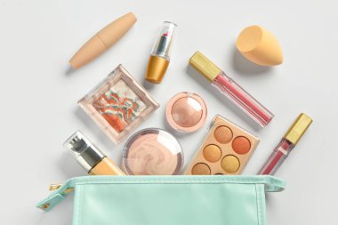 Beyaz arkaplanda dekoratif kozmetik ürünleri olan çanta