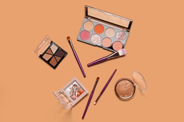 Turuncu arka planda farklı dekoratif kozmetik ürünler