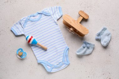Açık arkaplanda bebek kıyafetleri ve aksesuarları olan kompozisyon