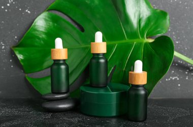 Kozmetik ürünleri ve koyu arkaplanda palmiye yaprağı bileşimi