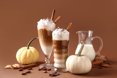 Kahverengi arka planda tarçınlı ve bademli balkabaklı latte.