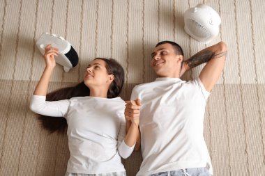 Elektrikli ısıtıcıları olan genç bir çift yerde el ele tutuşuyorlar.