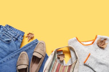 Şık kadın kıyafetleri, el çantası ve sarı arka planda ayakkabıları olan kompozisyon