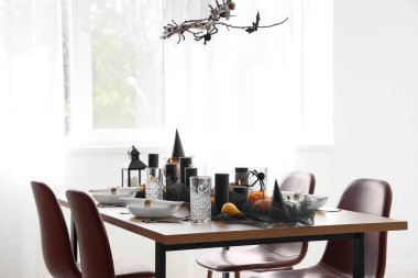 Cadılar Bayramı partisi için ışık odasında balkabakları ve yanan mumlarla şenlik masası.