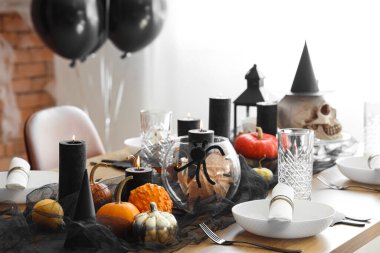 Festive table setting with pumpkins and burning candles for Halloween party at home clipart