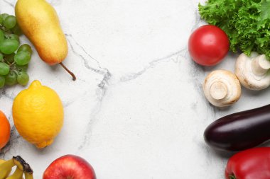 Taze sebzelerden yapılmış çerçeve ve beyaz mermer arka planda meyveler. Dünya Vegan Günü kavramı