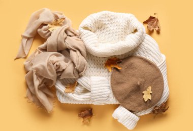 Şık kadın kıyafetleri ve arka planda düşmüş yaprakları olan kompozisyon