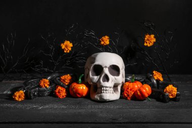 Siyah grunge arka planında kafatası, balkabağı ve prangalı Cadılar Bayramı kompozisyonu