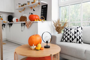 Cadılar Bayramı için masa ve kanepe ile dekore edilmiş aydınlık mutfak.