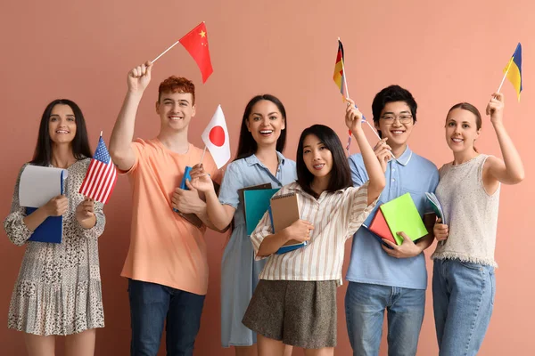 Junge Sprachschüler Mit Fahnen Auf Rosa Hintergrund — Stockfoto