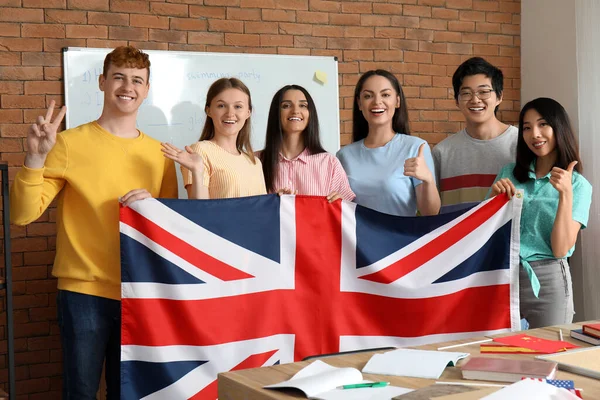 語学学校でイギリスの国旗を持つ若い学生 — ストック写真