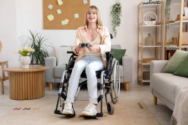 Stock image Young woman in wheelchair playing video game at home