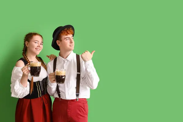 Junges Paar Traditioneller Deutscher Kleidung Mit Bier Zeigt Auf Etwas — Stockfoto