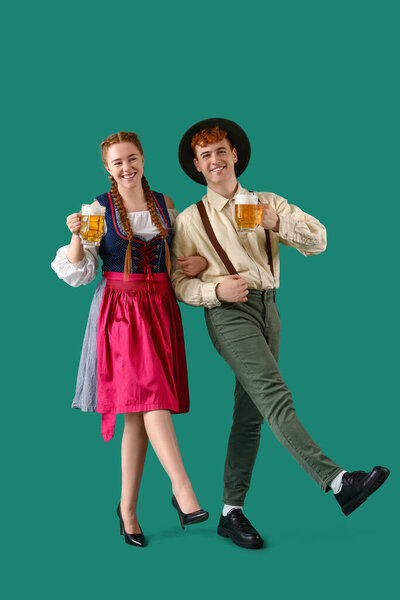 Молодая пара в традиционной немецкой одежде с танцами пива на зеленом фоне