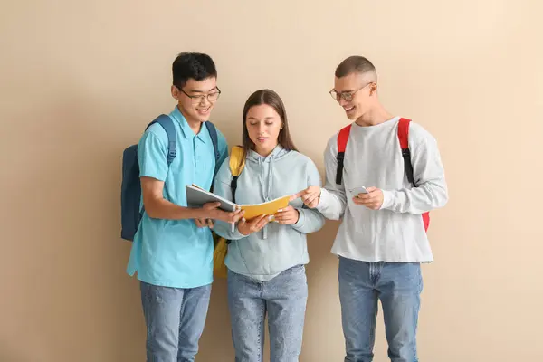Estudiantes Felices Con Mochilas Cuadernos Teléfono Móvil Sobre Fondo Beige — Foto de Stock