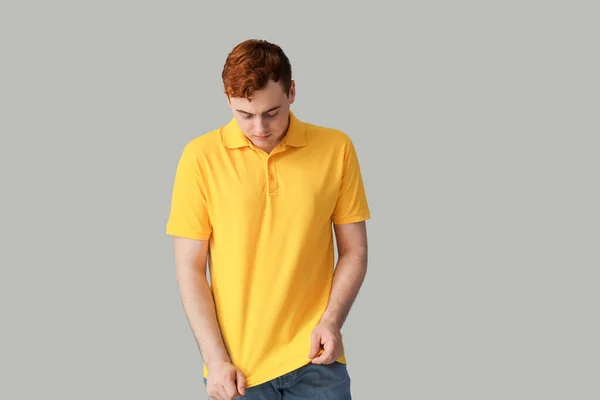 Молодой Человек Желтой Рубашке Поло Сером Фоне — стоковое фото