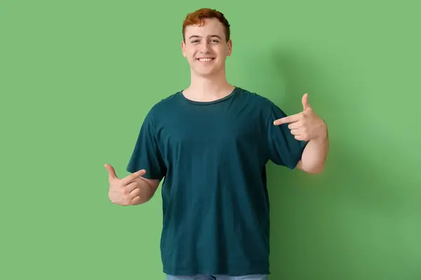Junger Mann Zeigt Auf Sein Shirt Auf Grünem Hintergrund — Stockfoto