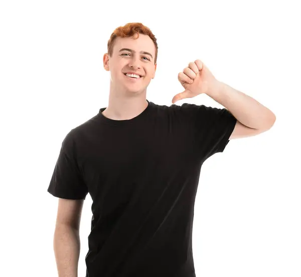 Junger Mann Zeigt Auf Sein Schwarzes Shirt Auf Weißem Hintergrund — Stockfoto