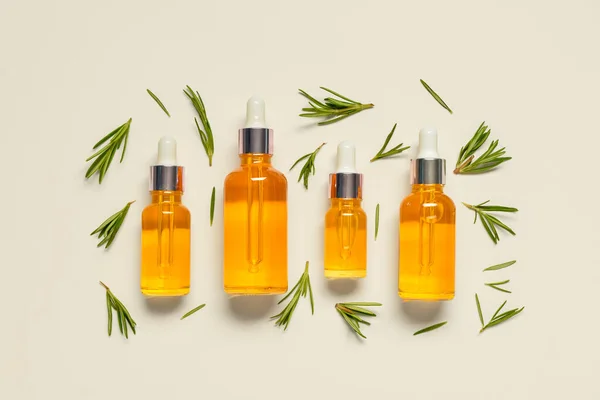 stock image Bottles of healthy essential oil with herbs on light background