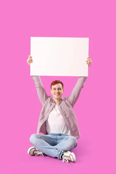 Homem Ruivo Jovem Feliz Com Cartaz Branco Sentado Fundo Roxo — Fotografia de Stock