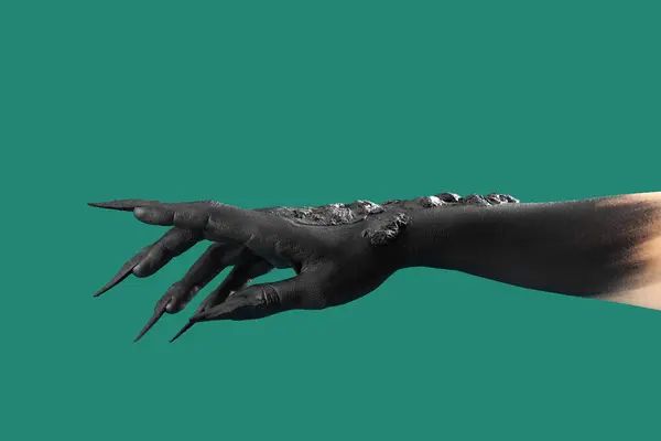 Black hand of witch with claws on green background. Halloween celebration