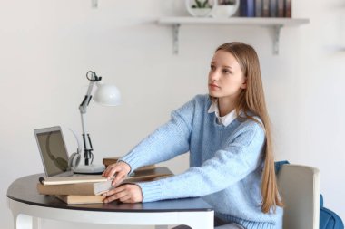 Kütüphanedeki masada okuyan kız öğrenci