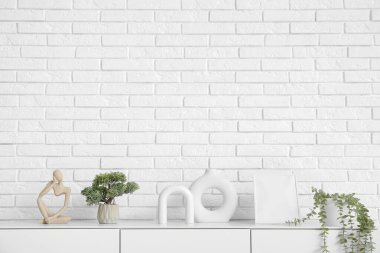 Beyaz tuğla duvarın yanında boş çerçeve ve dekorla yan pano