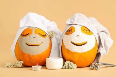 Maskeli balkabakları ve bej arka planda kaplıca malzemeleri