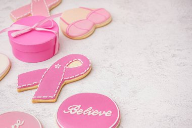 Kurdeleli pembe kurabiyeler ve beyaz grunge arka planda hediye kutusu. Göğüs kanseri farkındalığı konsepti