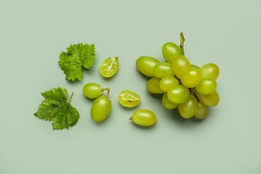 Renkli yaprakları olan taze yeşil üzümler.