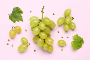 Leylak arka planında yaprakları ve tohumları olan taze yeşil üzümler.