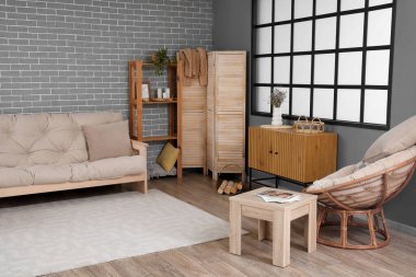 Koltuğu ve koltuğu olan bir oturma odası.