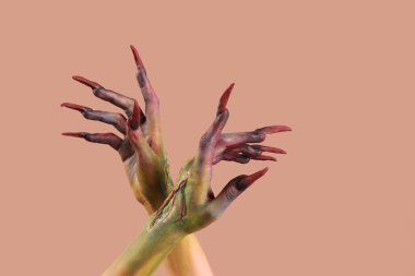 Pençeleri bej arka planda olan cadının elleri. Cadılar Bayramı