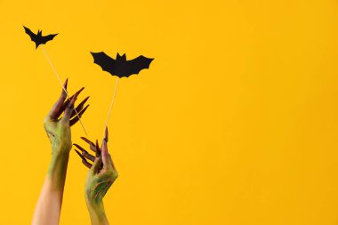 Sarı arka planda kağıt sopalı bir cadı. Cadılar Bayramı