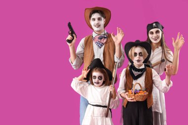 Mutlu aile Cadılar Bayramı için mor arka planda giyinmiş.